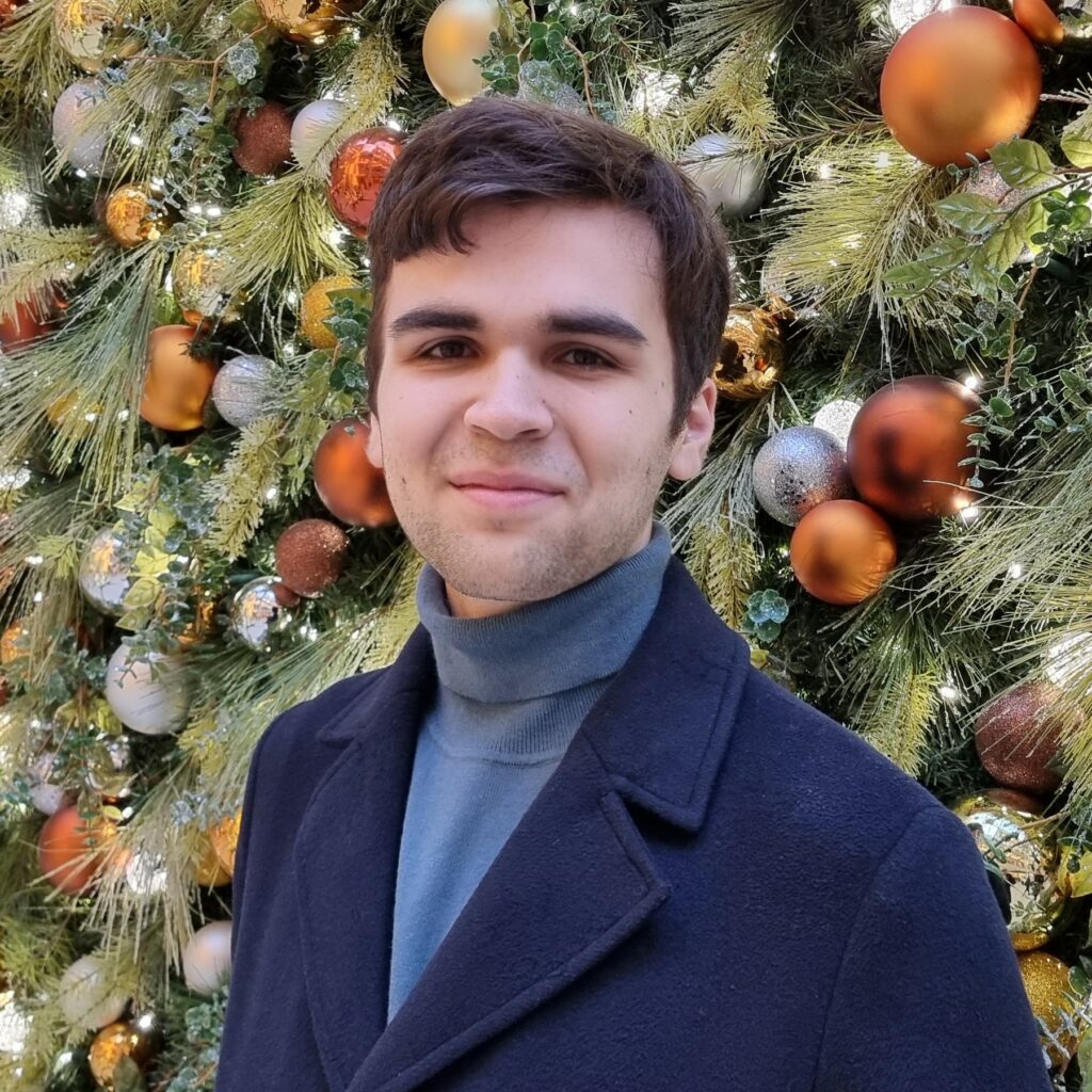 Benjamin Nicolas Tischler is a Director at Large at the PABC Board. He is standing in front of a holiday backdrop.
